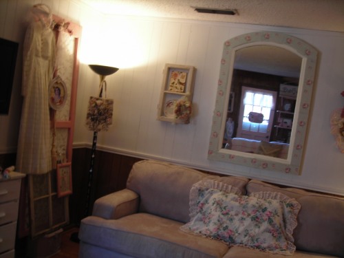 the mirror, after. hanging in my living room. painted it country white and glued sweet green/rose fabric to the frame. 